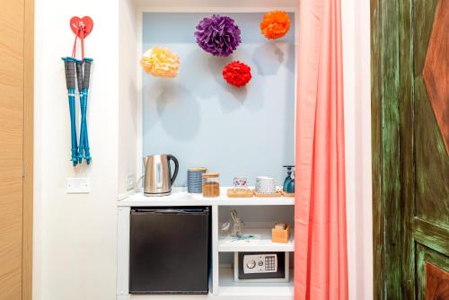 a room with a microwave and flowers on the wall at Carugio Remilde in La Spezia