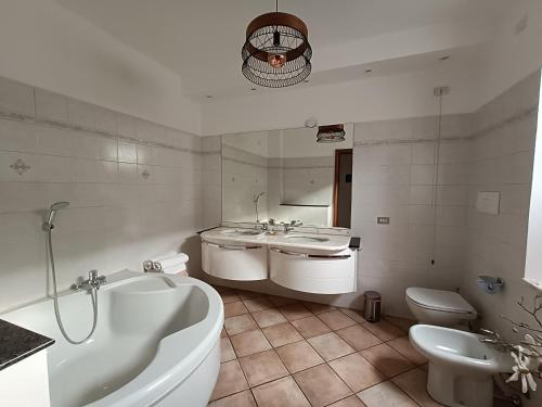 a bathroom with a tub and a sink and a toilet at Foresteria Sirio in Gorgonzola