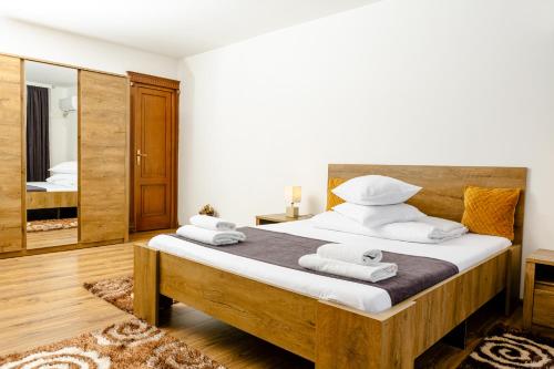 a bedroom with a large bed with towels on it at Pensiunea Pictorilor in Baia Mare