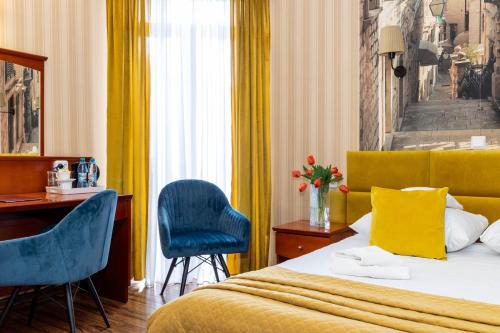 チェンストホヴァにあるホテル ヴェネツキのベッド、デスク、椅子が備わるホテルルームです。