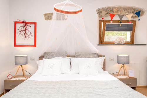 a bedroom with a bed with white sheets and a window at Carugio Remilde in La Spezia