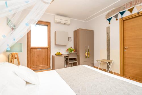 a bedroom with a white bed and a desk at Carugio Remilde in La Spezia