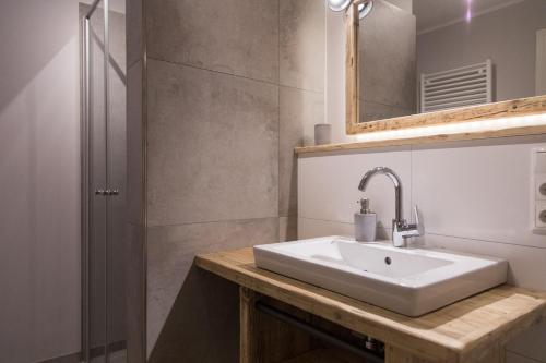 La salle de bains est pourvue d'un lavabo blanc et d'une douche. dans l'établissement Gulfhof Dreybült Dreybült 10 Wilko, à Dornum