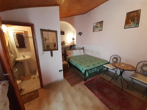 a bedroom with a bed and a table and a sink at The little house in Ágios Matthaíos