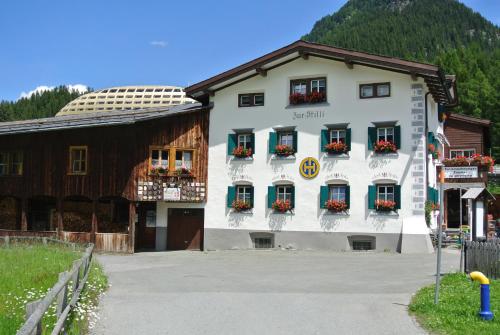 a white building with flowers on the windows at Pension Hof zur Stilli in Davos