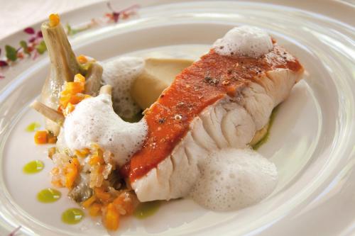 a plate of food with a piece of fish and vegetables at Benvengudo in Les Baux-de-Provence