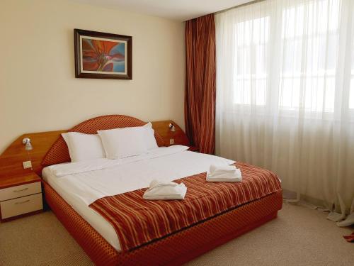 a bedroom with a bed with two towels on it at Sofia hotel apartments in Sofia
