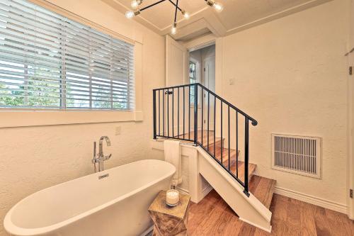 a white bath tub in a bathroom with a staircase at Ridgeline Retreat with Mountain Lake Views! in Lake Arrowhead