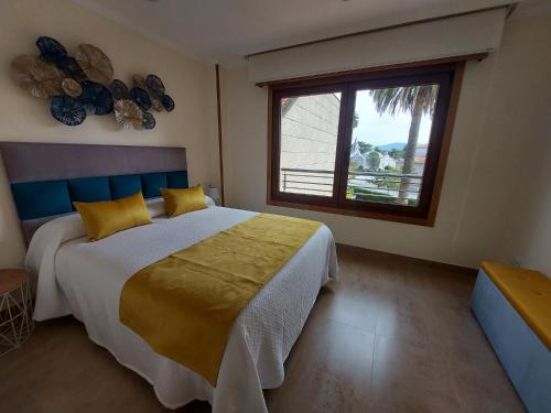 a bedroom with a large bed and a window at Magnífico apartamento en el corazón de La Toja in Isla de la Toja