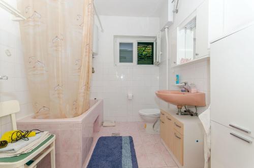 bagno con vasca, lavandino e servizi igienici di Apartments KATA a Supetar (San Pietro di Brazza)