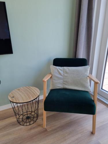 a chair with a pillow and a table in a room at Vakantie vieren aan het Sneekermeer in Offingawier