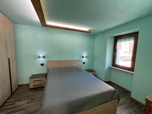 1 dormitorio con cama y ventana en Casa Carral, en Aymavilles
