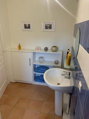 une salle de bain avec un lavabo blanc et un miroir dans l'établissement Majellon Grand Appartement, à Sainte-Christie-dʼArmagnac