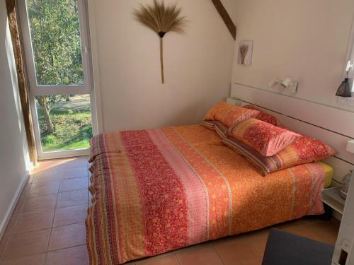 a bedroom with a bed and a large window at Majellon Grand Appartement in Sainte-Christie-dʼArmagnac