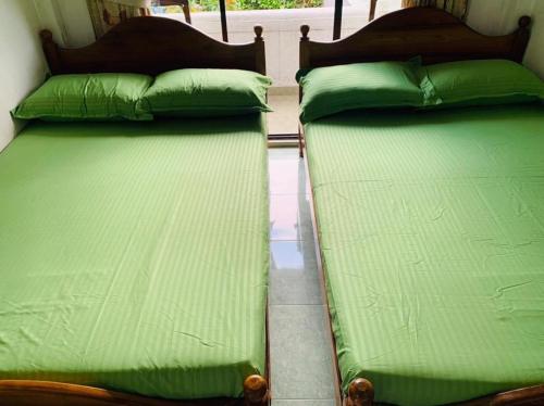 two beds sitting next to each other in a room at Miliya Guest House in Nuwara Eliya