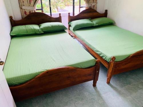 two twin beds sitting next to each other in a room at Miliya Guest House in Nuwara Eliya