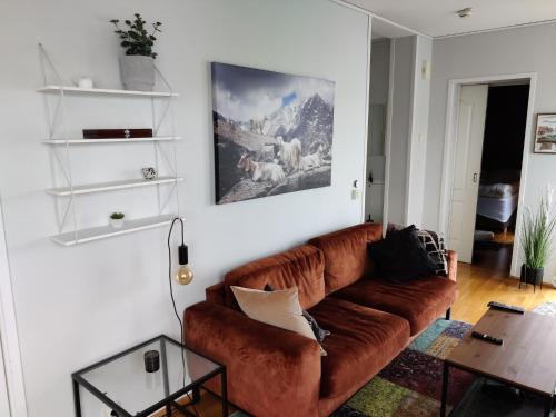 a living room with a brown couch and a table at Top floor apartment with a magic view in Tromsø