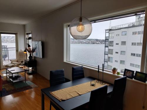 a dining room with a table and a large window at Top floor apartment with a magic view in Tromsø