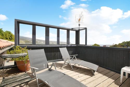 two chairs on a deck with a view of the ocean at Casa Munay in Granadilla de Abona