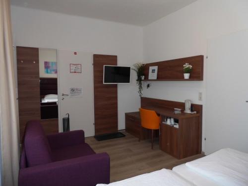 a hotel room with a bed and a desk and a chair at Pension Elisabeth - Rooms & Apartments in Salzburg