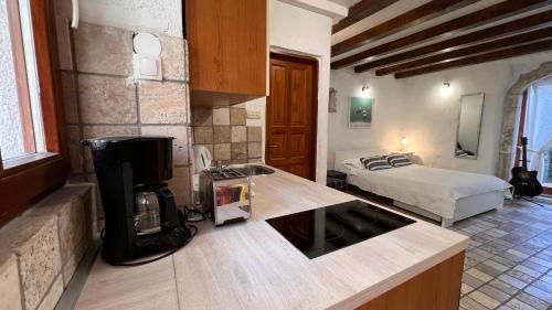 a kitchen with a coffee maker and a bed at Guesthouse F in Split