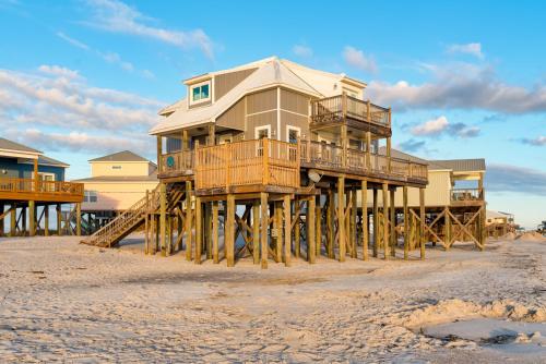 a house on wooden posts on the beach at Strand Castle - GULF FRONT! An ideal layout with game room, small private pool, and roof top crow's nest! home in Dauphin Island