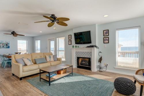 uma sala de estar com um sofá e uma lareira em Island Escape - Gulf Access and Pet Friendly - Plus AMAZING views from the CROWS NEST! home em Dauphin Island