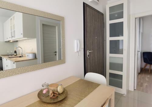 een keuken en eetkamer met een tafel en een spiegel bij La Perla Apartment Podstrana (Split riviera) in Podstrana
