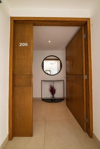 a hallway with a door and a round mirror at 87978 DELUXE and unique 3BR condo by The Harbor, Via Montejo in Mérida