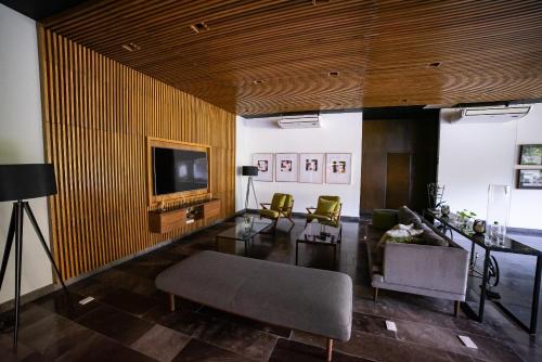 a living room with a television and a table and chairs at 87978 DELUXE and unique 3BR condo by The Harbor, Via Montejo in Mérida