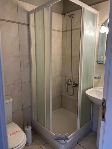 a bathroom with a shower with a toilet and a sink at Mira Mare Hotel, Galaxidi in Galaxidi