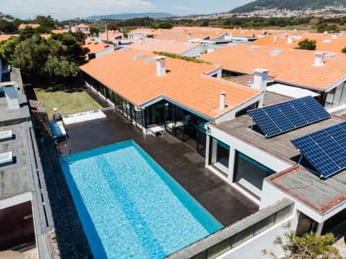an aerial view of a house with a swimming pool and solar panels at FOZ DO NEIVA 16 Estadia de luxo em Foz do Neiva Esposende Portugal in Moldes
