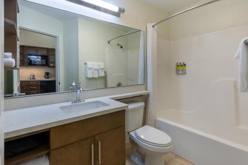 a bathroom with a sink and a toilet and a mirror at Candlewood Suites-West Springfield, an IHG Hotel in West Springfield