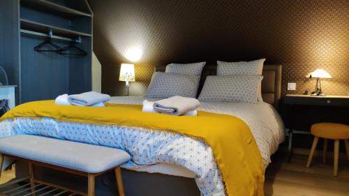 a bedroom with a large bed with a yellow and blue blanket at Les coquelicots - Chambre Alex in Houdan