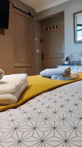 a bedroom with two beds with towels on the floor at Les coquelicots - Chambre Alex in Houdan