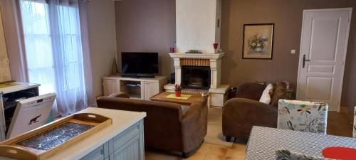 a living room with a couch and a fireplace at Gîte et chambres d'hôtes Le Chêne Billault in Pouant
