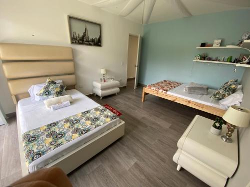 Habitación con 2 camas y mesa. en Finca Hotel Estrella del Eden, en Armenia