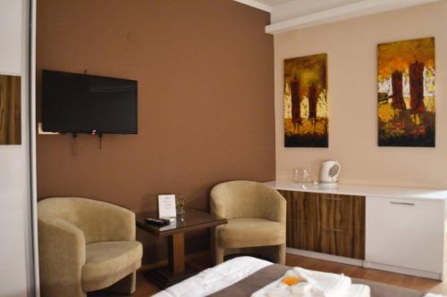 a room with two chairs and a table and a tv at City House Bitola in Bitola