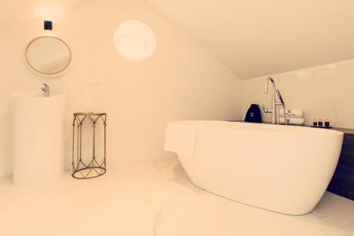 a white bathroom with a sink and a mirror at Dwór w Żytnie in Żytno