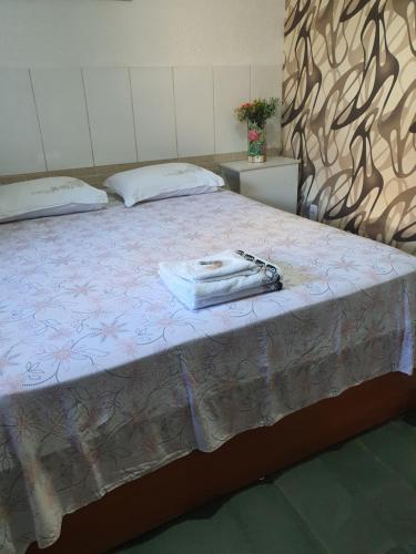 Una cama con un bolso encima. en Suíte 08 - Aconchegante e Exclusiva, en Cuiabá