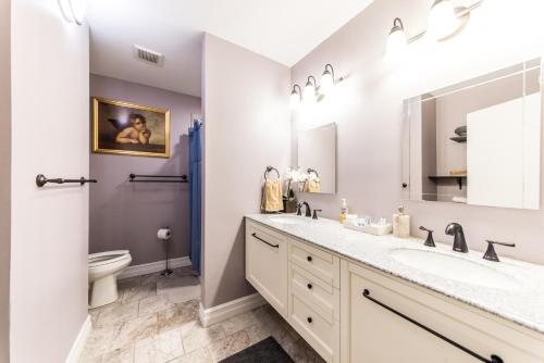La salle de bains est pourvue de 2 lavabos et de toilettes. dans l'établissement DowntoWn Abbey, à Saint-Louis