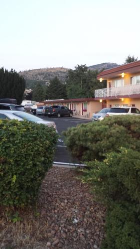a parking lot with cars parked in front of a building at Swiss Sunset Inn in Penticton