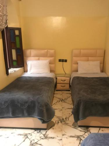 two beds sitting next to each other in a bedroom at Dar Ibrahim in Rabat