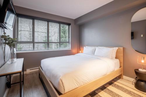 a bedroom with a large bed and a window at Eagle Lodge 225 by Outpost Whistler in Whistler