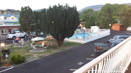a view of a parking lot with a pool and cars at Swiss Sunset Inn in Penticton