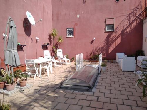a patio with a table and chairs and a pink building at A Casa di Monica in Pozzuoli