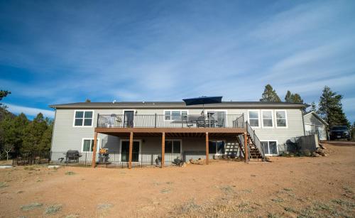 a large white house with a porch and a deck at 24 Quiver Circle Spectacular Mountain View 5 Acres PIKES PEAK in Florissant