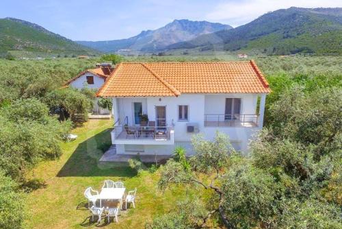 a small white house with an orange roof in a field at Elena's Suite in Skala Rachoniou