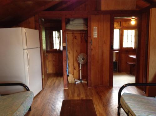 a kitchen with a refrigerator and a room with wooden walls at Addison's Bungalows in Brisco