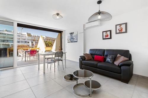 een woonkamer met een bank en een tafel bij Village Naturiste R4N - Le Rocca V Héliopolis Luxe in Cap d'Agde